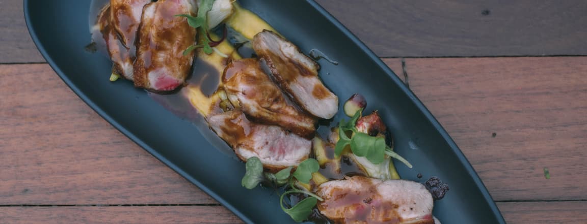 Slices of duck breast with raspberry and butternut squash cream