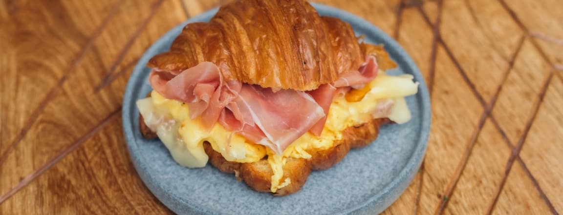 Croissant with serrano ham, scramble eggs and cheese