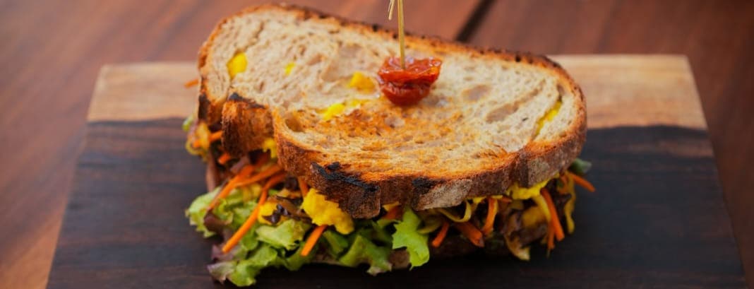 Yellow curry veggies sandwich and hummus with greens.