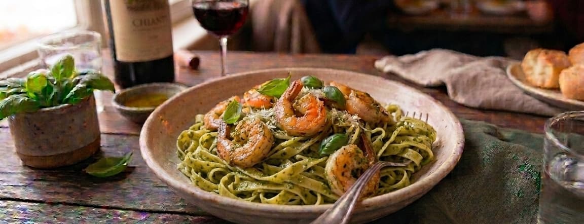 Spaghetti or fettuccine pasta with shrimps and pesto sauce